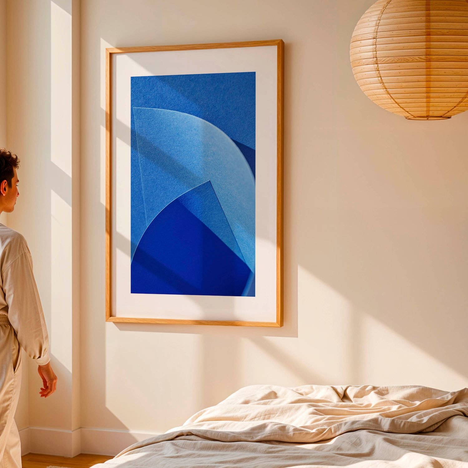 Een kamer waar een lage meubel staat naast het raam met daarop een witte kader met daarin geometrische kunst